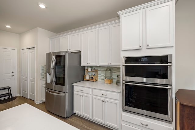 kitchen featuring appliances with stainless steel finishes, white cabinets, and light countertops