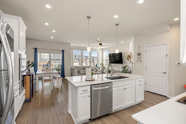 kitchen featuring an island with sink, recessed lighting, open floor plan, and appliances with stainless steel finishes