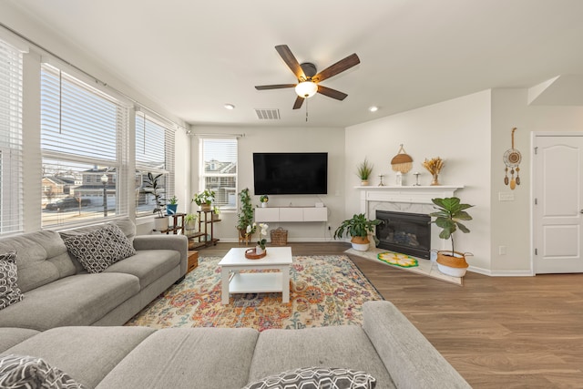 living area with visible vents, wood finished floors, recessed lighting, a fireplace, and baseboards