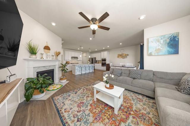 living area featuring ceiling fan, wood finished floors, and recessed lighting