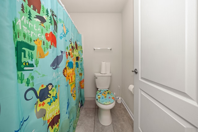 bathroom with tile patterned flooring, toilet, a shower with shower curtain, and baseboards