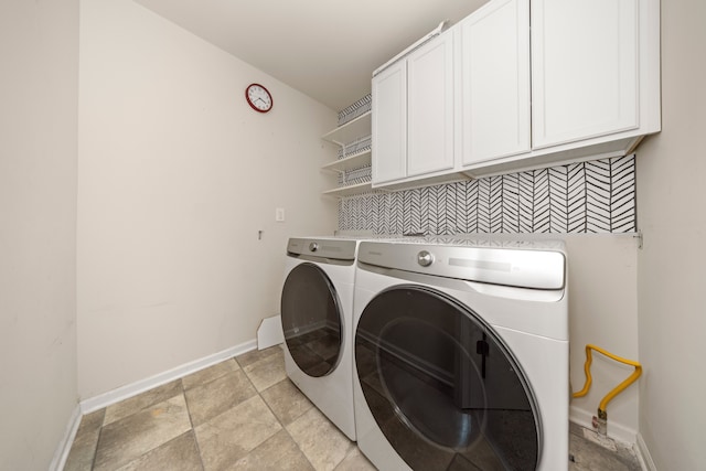 washroom with cabinet space, independent washer and dryer, and baseboards