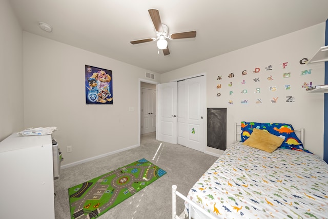 carpeted bedroom featuring ceiling fan, visible vents, a closet, and baseboards