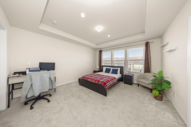 bedroom with a raised ceiling, carpet, and baseboards