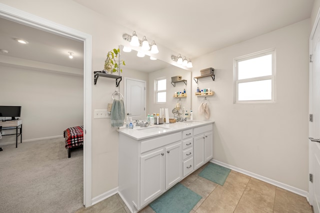 bathroom featuring double vanity, baseboards, and a sink