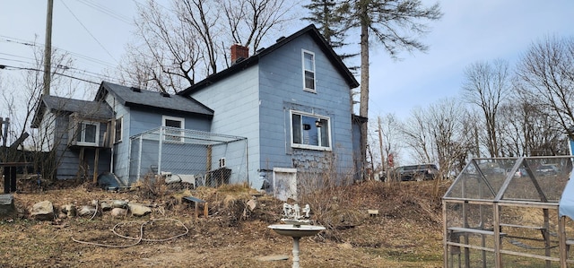 view of property exterior featuring an outdoor structure and a chimney