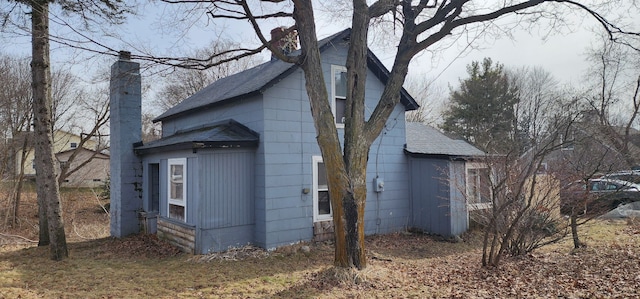 view of property exterior featuring a chimney and a shingled roof