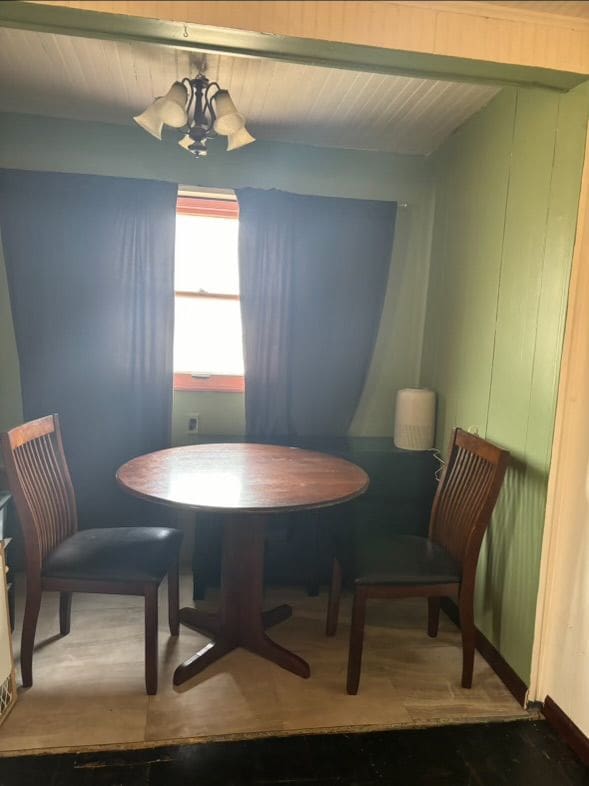 dining area featuring beamed ceiling and a chandelier