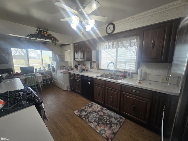 kitchen with black appliances, washing machine and dryer, a sink, and a healthy amount of sunlight