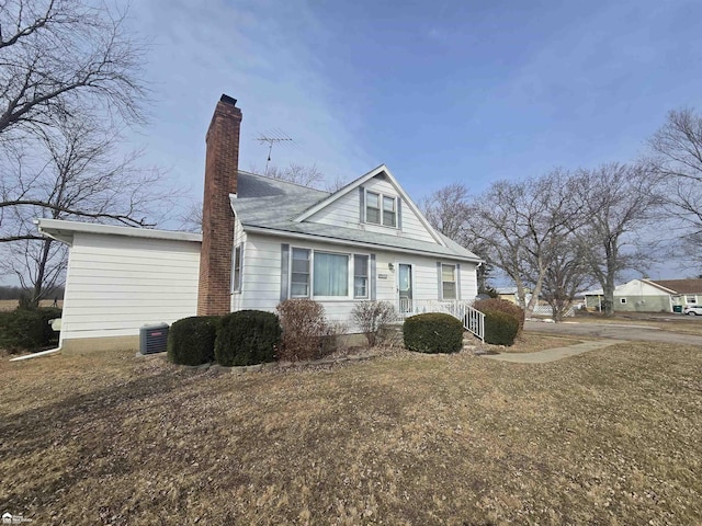 bungalow featuring a shingled roof, a chimney, and central AC unit