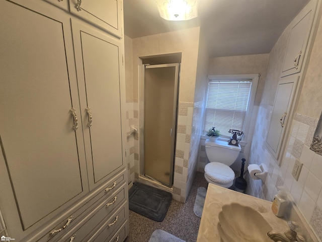 full bath featuring a sink, wainscoting, a shower stall, and tile walls