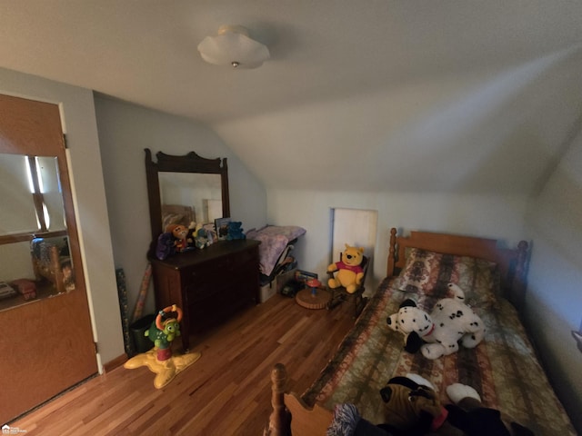 bedroom with vaulted ceiling and wood finished floors