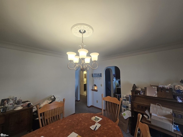 carpeted dining room with a chandelier, arched walkways, and crown molding