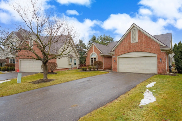 view of front of home with aphalt driveway, brick siding, a shingled roof, and a front lawn