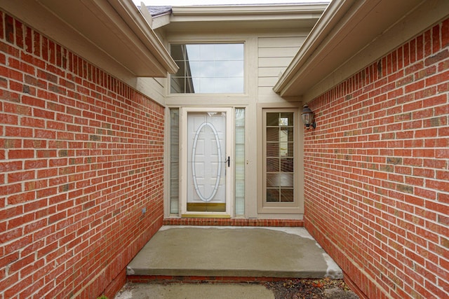 view of exterior entry featuring brick siding