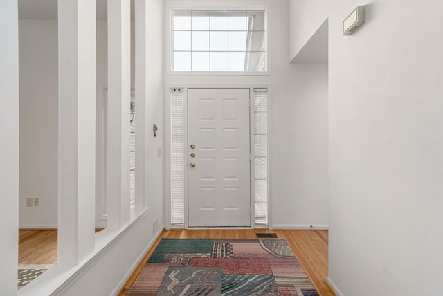 foyer entrance with wood finished floors, visible vents, and baseboards