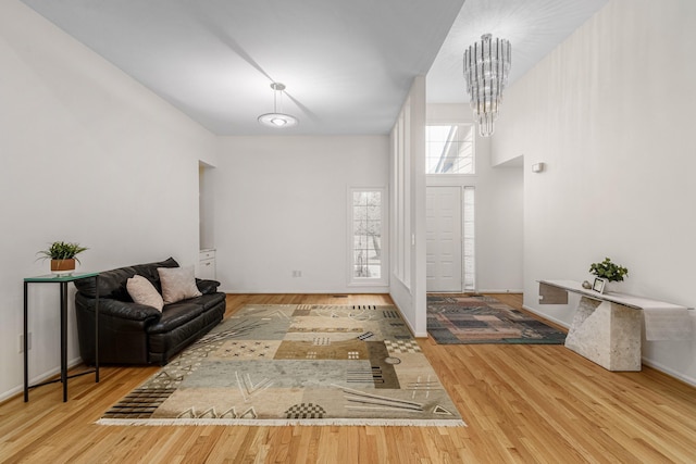 entrance foyer with an inviting chandelier, baseboards, and wood finished floors