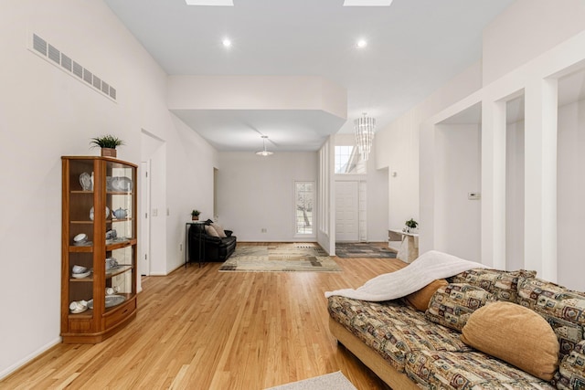 interior space with a skylight, baseboards, visible vents, light wood-style floors, and recessed lighting