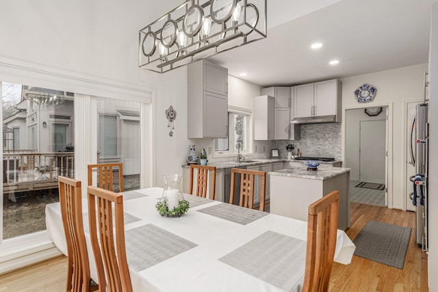 dining area featuring a notable chandelier, recessed lighting, and light wood-style floors