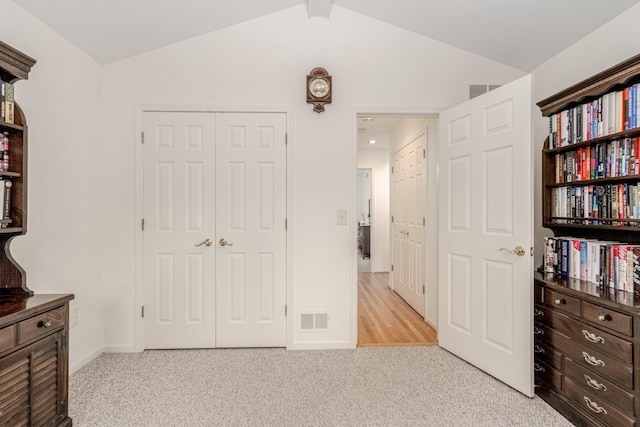 bedroom featuring light carpet, baseboards, visible vents, vaulted ceiling, and a closet