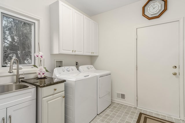 laundry area with washer and clothes dryer, visible vents, cabinet space, a sink, and baseboards