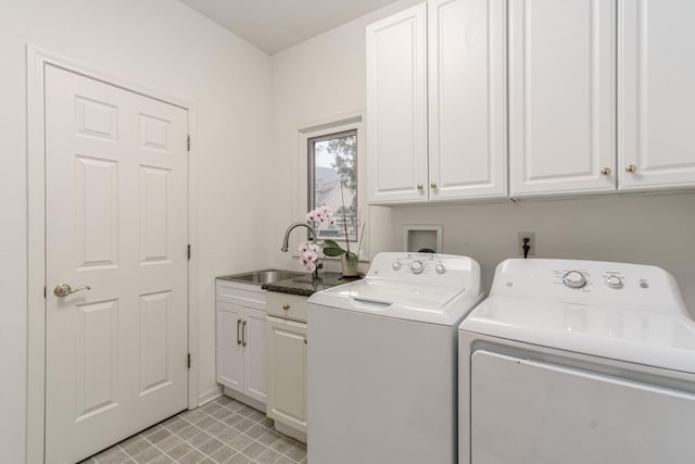 clothes washing area with cabinet space, a sink, and washing machine and clothes dryer