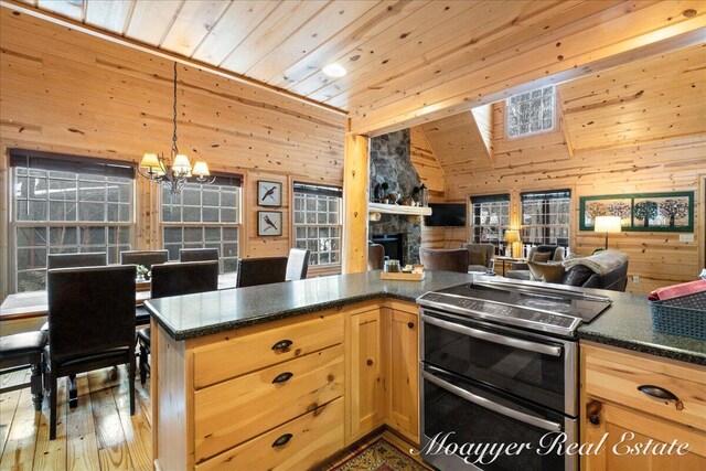 kitchen featuring open floor plan, wooden walls, wood ceiling, and double oven range