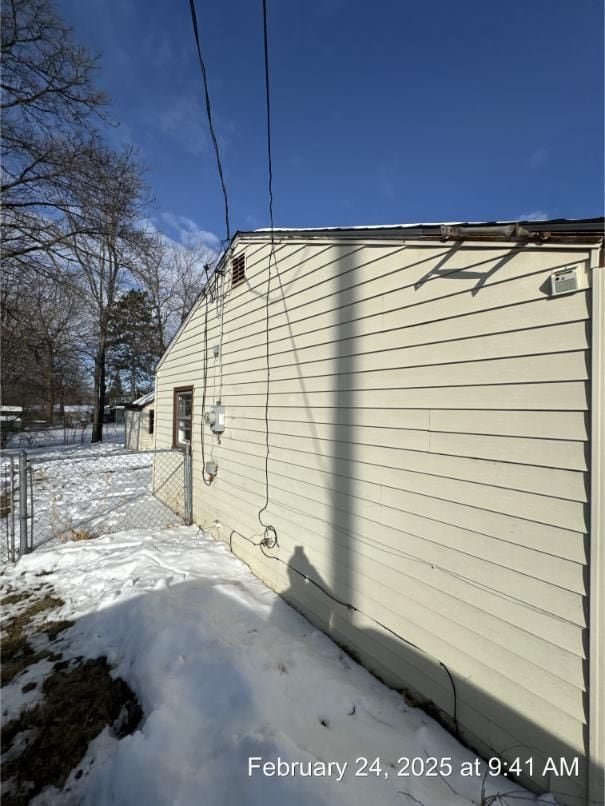 view of snowy exterior featuring fence