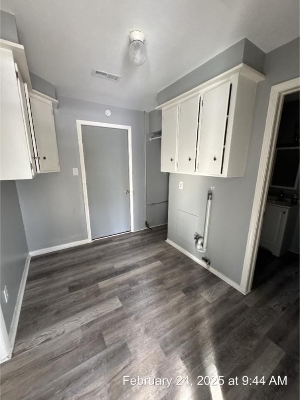 clothes washing area featuring laundry area, baseboards, visible vents, and dark wood finished floors