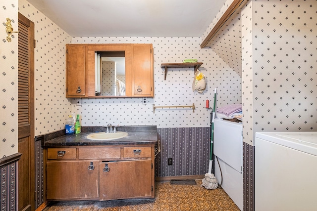 bathroom featuring vanity, washer / dryer, and wallpapered walls