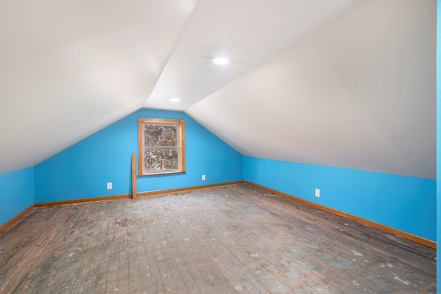 additional living space featuring lofted ceiling, baseboards, and hardwood / wood-style floors