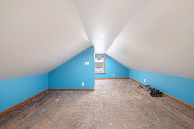 bonus room with baseboards, vaulted ceiling, and hardwood / wood-style floors