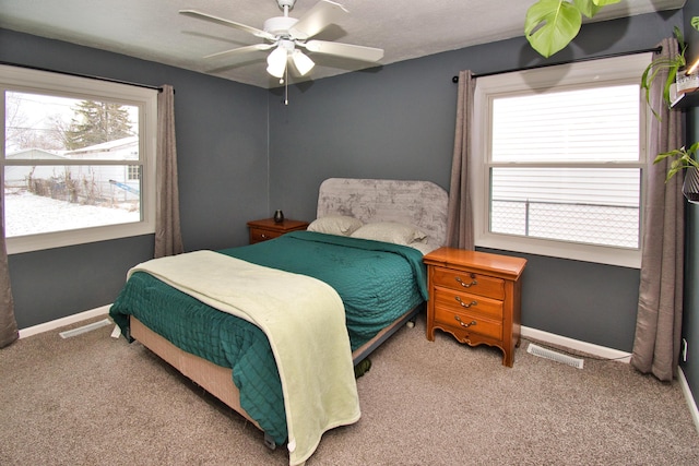 carpeted bedroom featuring ceiling fan, visible vents, and baseboards