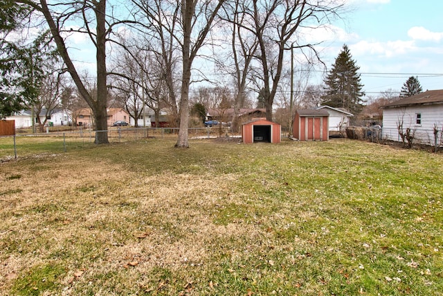 view of yard with a fenced backyard, an outdoor structure, and a storage unit