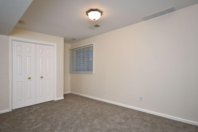 unfurnished bedroom featuring a closet, carpet, visible vents, and baseboards