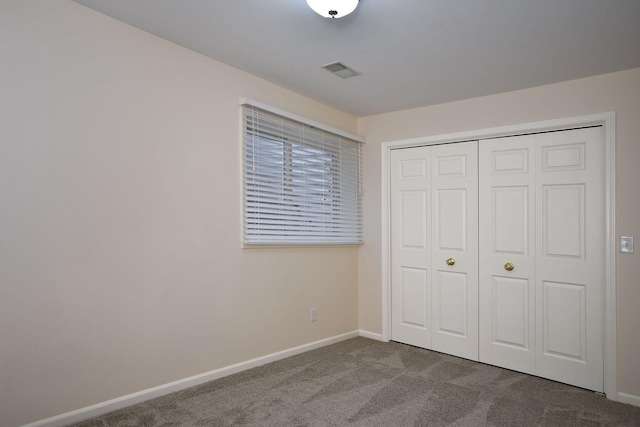 unfurnished bedroom featuring a closet, baseboards, visible vents, and carpet flooring