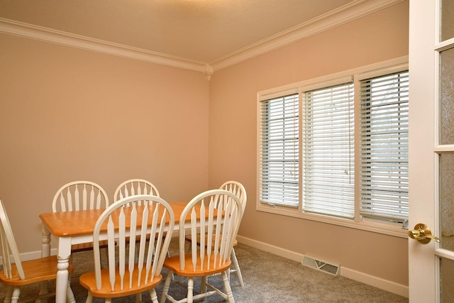 dining space with ornamental molding, carpet, visible vents, and baseboards