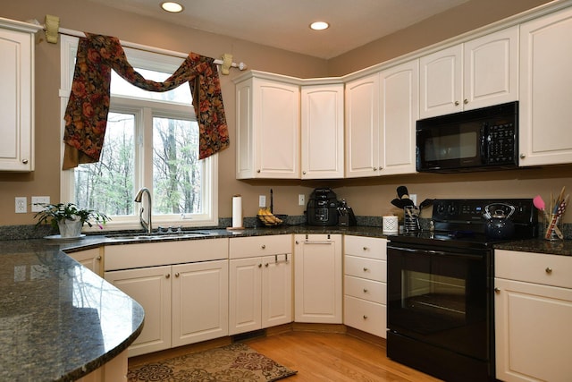 kitchen with black appliances, white cabinets, and a sink