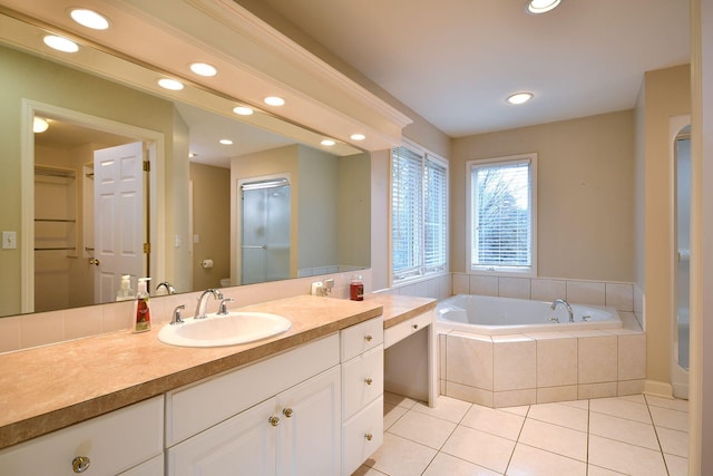 bathroom with a garden tub, recessed lighting, vanity, and tile patterned floors