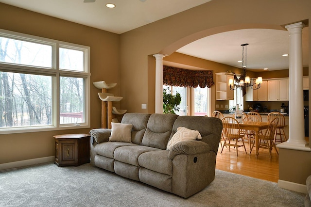 living room featuring decorative columns, arched walkways, and baseboards