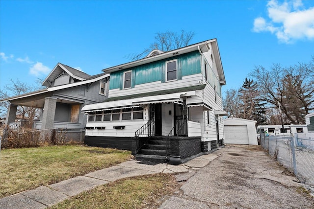 view of front facade featuring a front yard, fence, driveway, and an outdoor structure