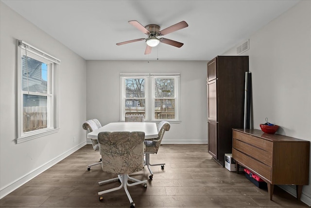 dining space with a wealth of natural light, dark wood finished floors, and visible vents