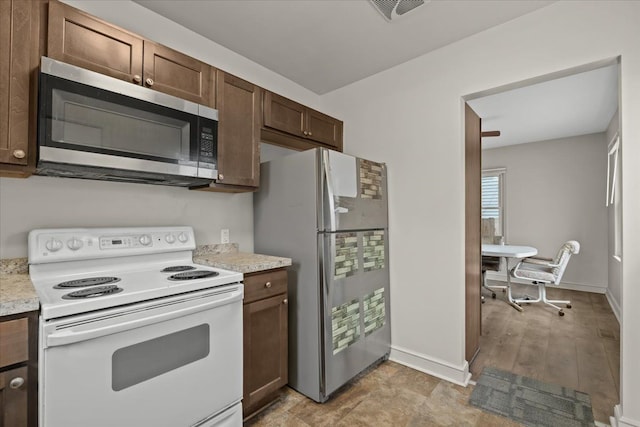 kitchen featuring dark brown cabinetry, visible vents, baseboards, light countertops, and appliances with stainless steel finishes