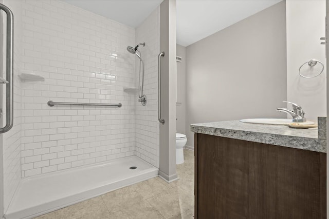 bathroom with tile patterned flooring, toilet, vanity, baseboards, and a shower stall