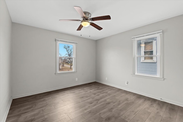 empty room featuring ceiling fan, wood finished floors, and baseboards