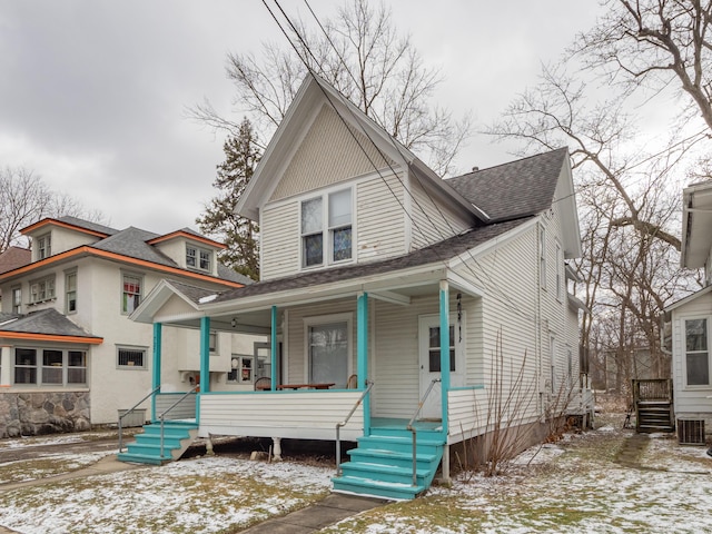 view of front facade featuring a shingled roof, a porch, and cooling unit