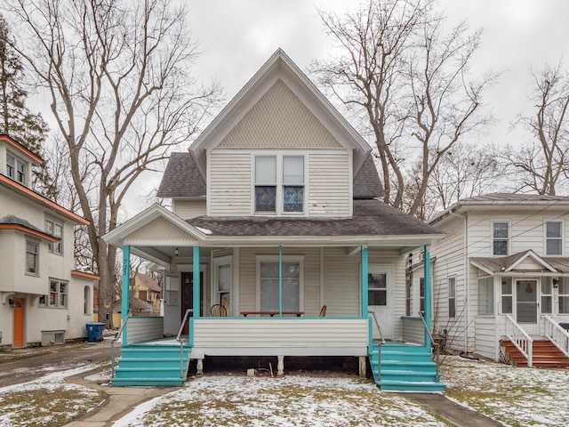 view of front facade with covered porch and roof with shingles