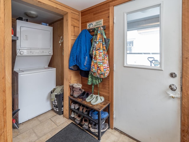 washroom featuring laundry area, wooden walls, and stacked washer / drying machine