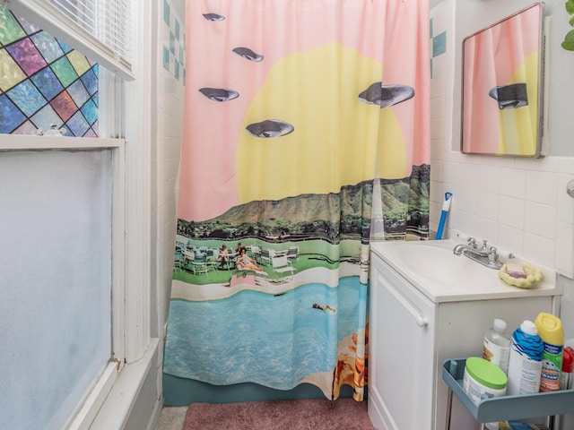 bathroom featuring curtained shower, tile walls, and vanity