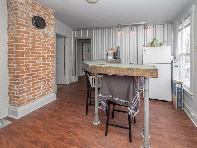 kitchen with plenty of natural light, wood finished floors, freestanding refrigerator, and baseboards